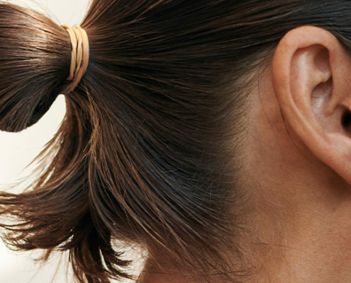 The profile of a woman with her hair tied back in a bun