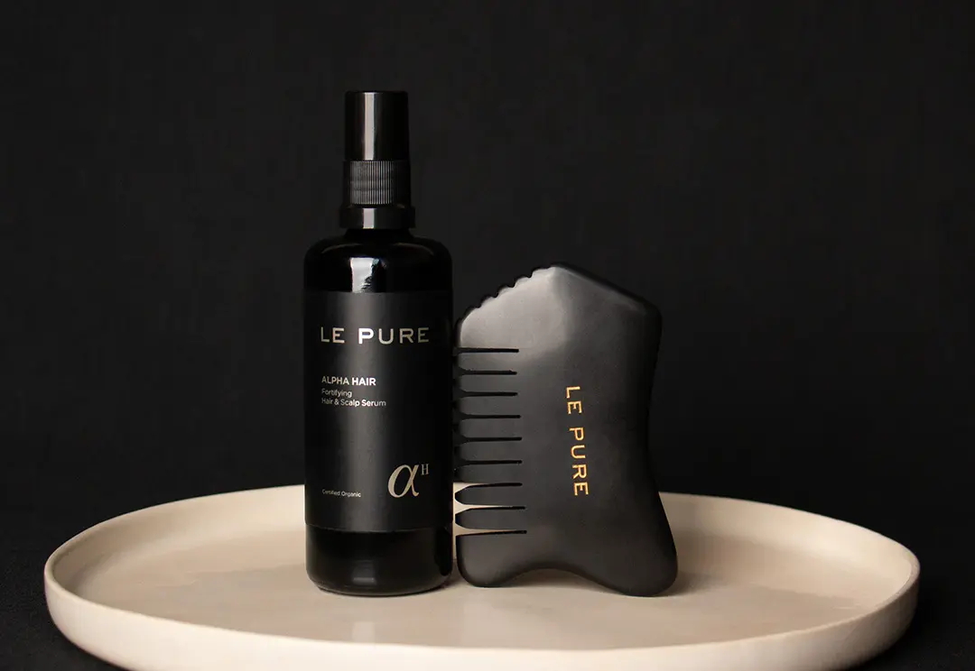 Alpha Hair et peigne gua sha sur une assiette