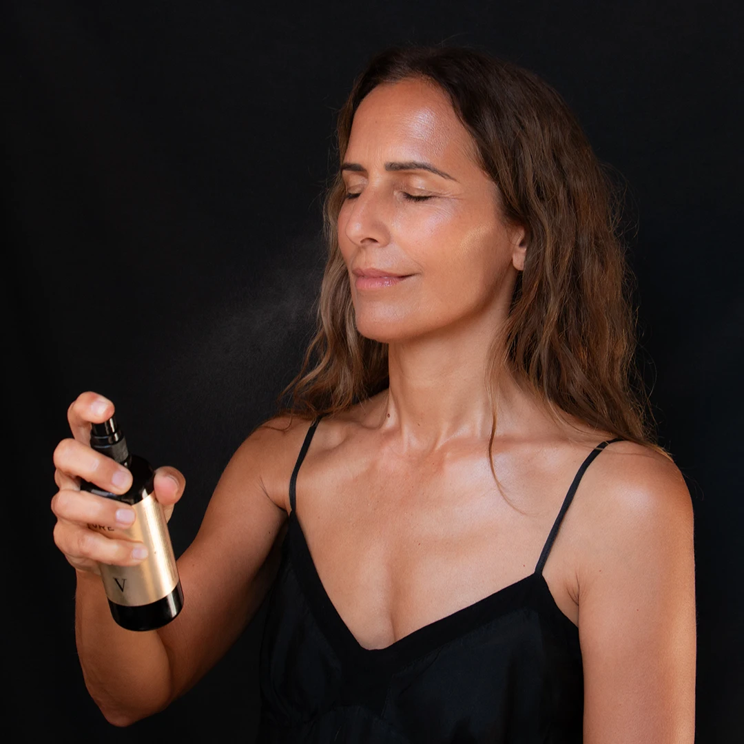 Woman spraying LE PURE Velvet Hydration essence onto her face for instant relaxation, lifting, and firming action